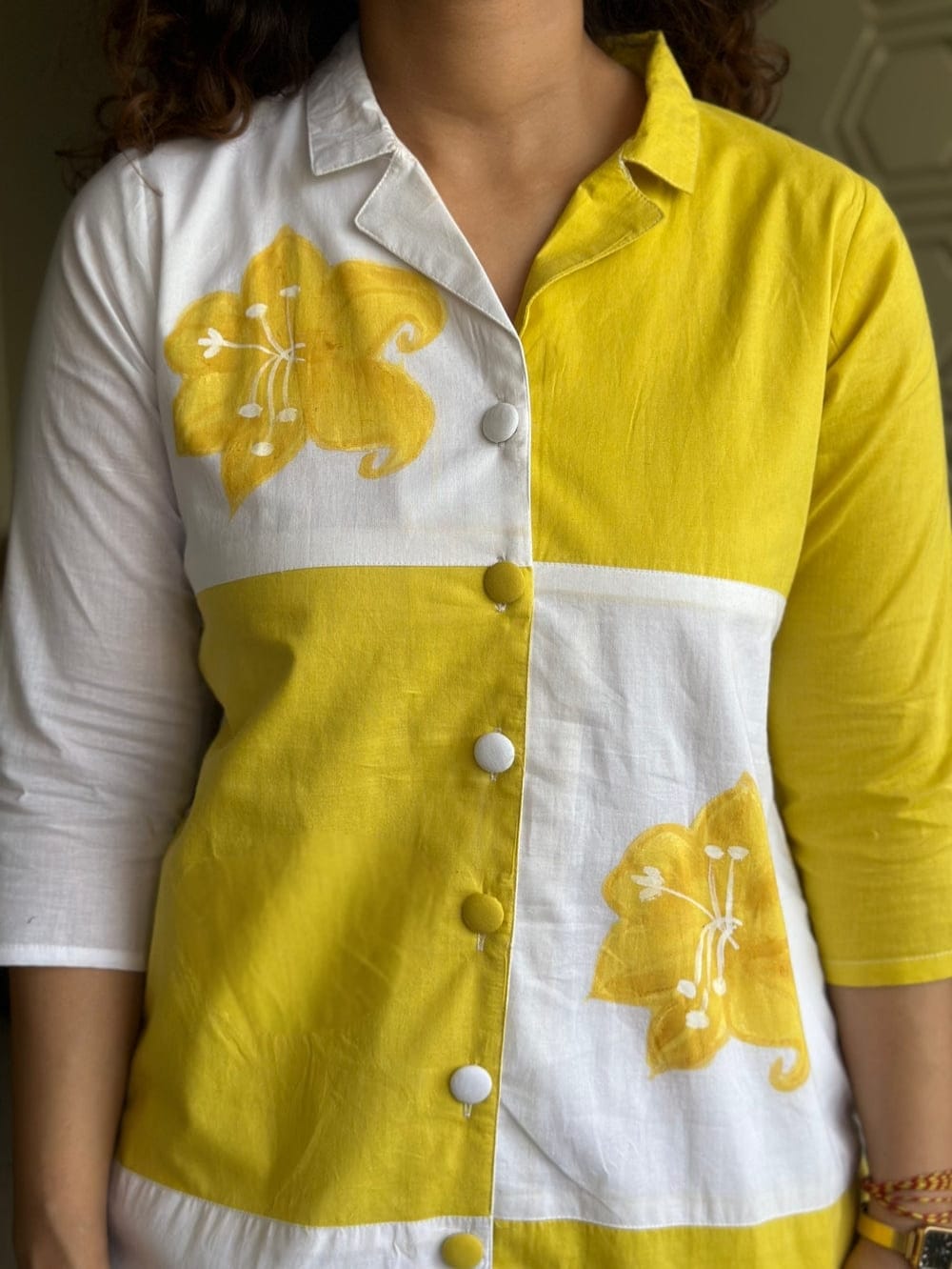 Close-up of yellow co-ord set with floral design and buttons