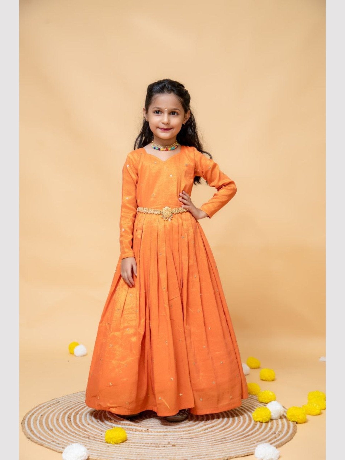 Full view of girl in orange silk gown, hands on hips