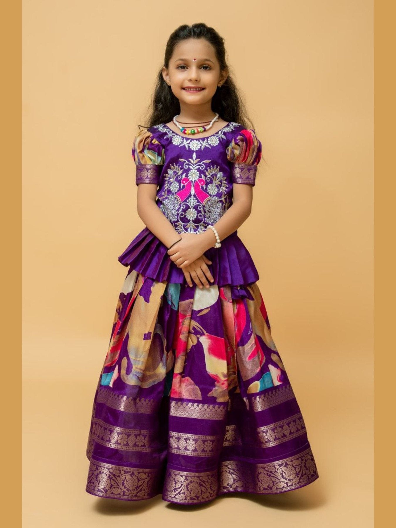 Girl wearing purple festive lehenga choli, smiling