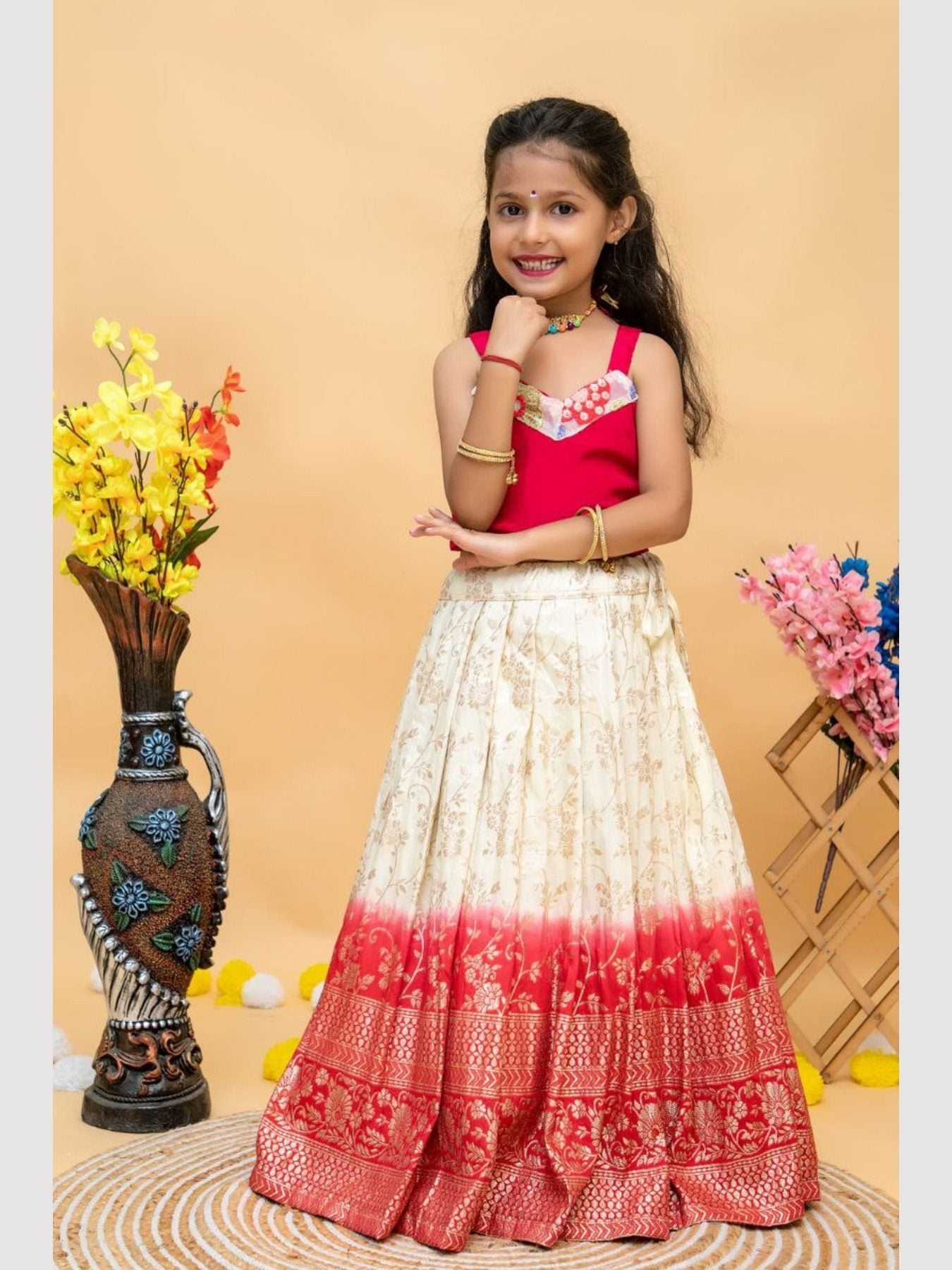 Girl in red and cream lehenga choli with floral jacket