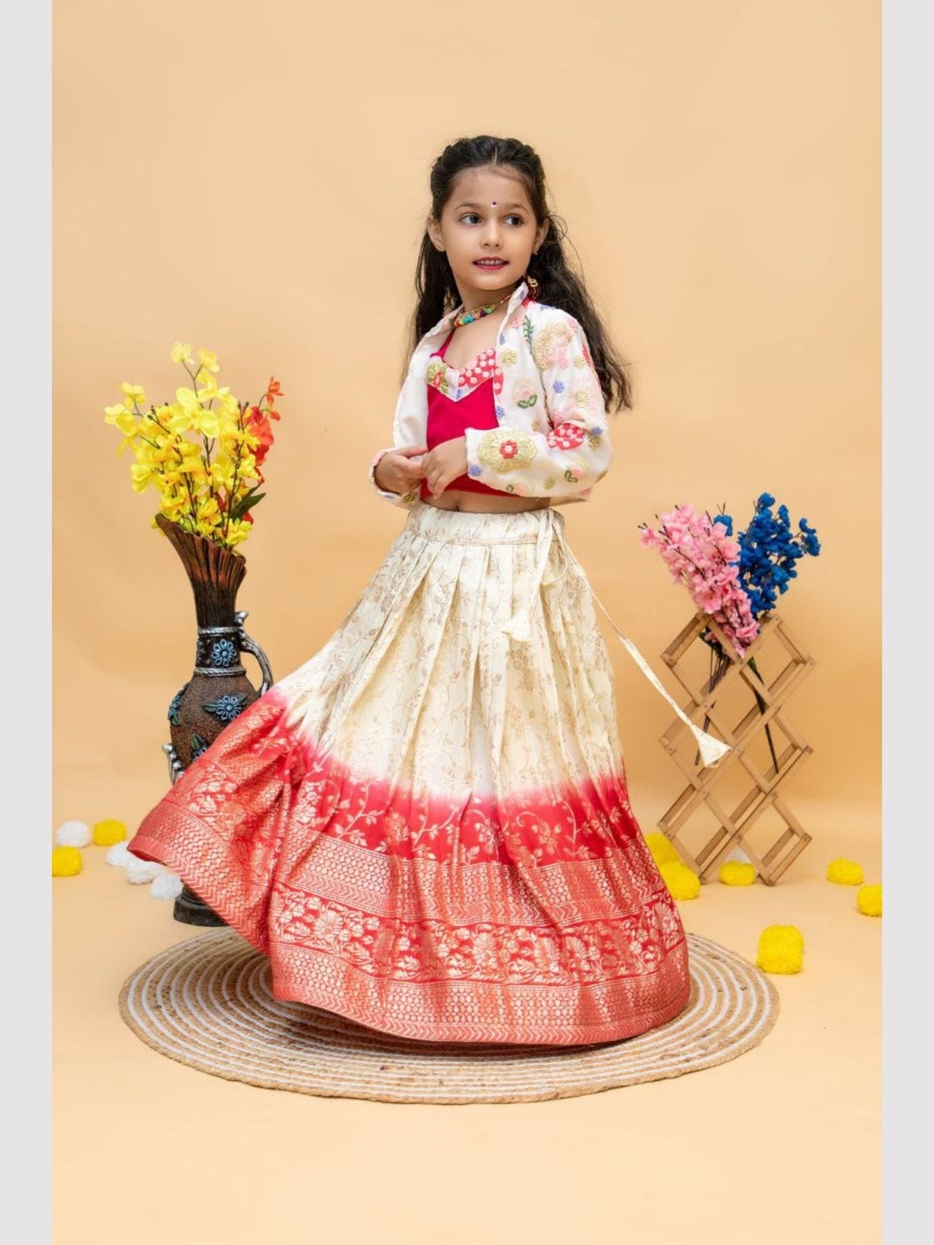 Girl twirling in red and cream lehenga choli with jacket